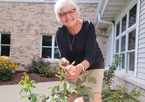 a sister of St. Francis of the Holy Cross, Bay Settlement Wisconsin tending to flowers in front of a building