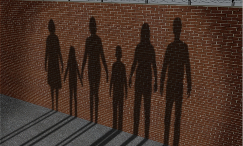 the silhouette of six people of various ages cast against a brick wall