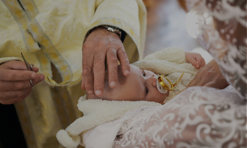 a baby being blessed by a priest